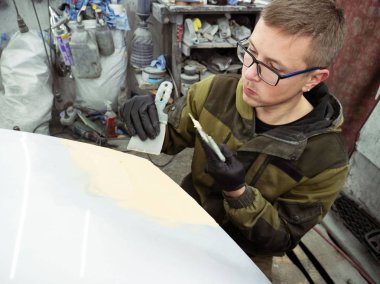 gözlük lüzifi siyah eldiven bir garajın bir araba kapağı bölümü ile sevimli adam