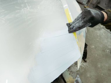 gözlük lüzifi siyah eldiven bir garajın bir araba kapağı bölümü ile sevimli adam