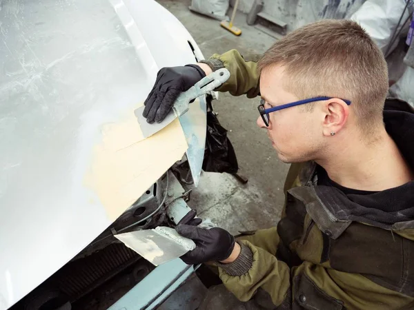 gözlük lüzifi siyah eldiven bir garajın bir araba kapağı bölümü ile sevimli adam