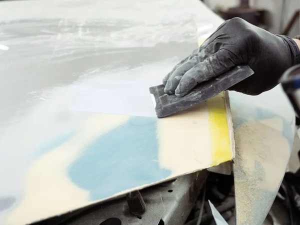 Gözlüklü Şirin turuncu eldiven bir garajda araba başlık bölümünü macun