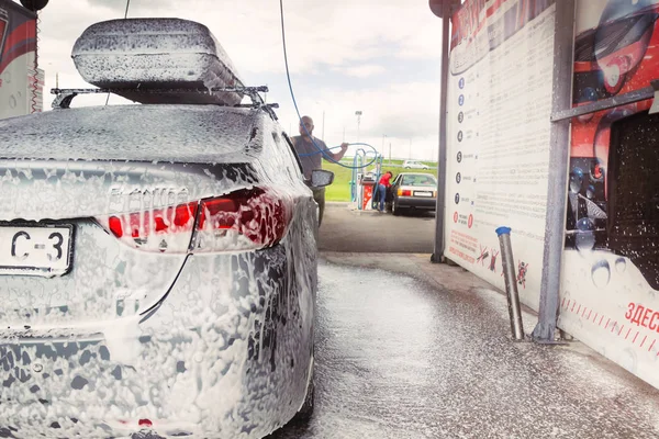 Gomel, Belarus - 4 Ağustos 2019: Gözlüklü sakallı bir adam gümüş renkli araba yıkar Hyundai Elantra GLS