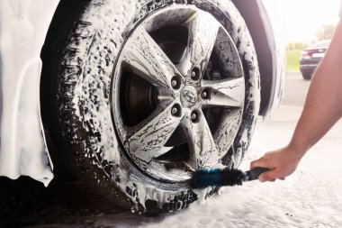 Gomel, Beyaz Rusya - 4 Ağustos 2019: Bir adam Nlandai Elantra araba Gls bir tekerlek sayacı ile gümüş bir tekerlek temizler