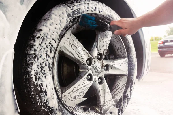 Gomel, Beyaz Rusya - 4 Ağustos 2019: Bir adam Nlandai Elantra araba Gls bir tekerlek sayacı ile gümüş bir tekerlek temizler