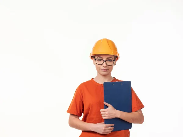 白い背景に青いフォルダを持つ黄色のヘルメットの美しいフォアマンの女の子 — ストック写真