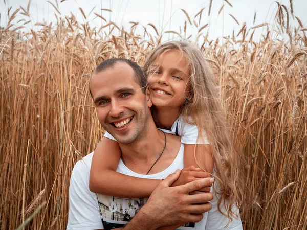 Mutlu baba ve kızı buğday tarlasında eğleniyor.