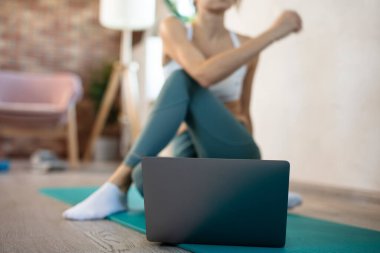 Genç, spor düşkünü kadının internetteki spor eğitmeni modern laptop ekranı var. Sağlıklı yaşam tarzı konsepti, online fitness ve spor dersleri. Çevrimiçi esneme.
