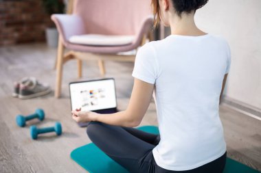 Genç, spor düşkünü kadının internetteki spor eğitmeni modern laptop ekranı var. Sağlıklı yaşam tarzı konsepti, online fitness ve spor dersleri. Çevrimiçi esneme.