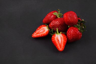 Siyah arka plan üzerinde olgunlaşmış taze çilek. Meyve yakın çekim