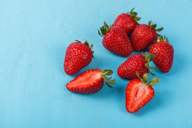 Mavi arka plan üzerinde olgunlaşmış taze çilek. Meyve yakın çekim