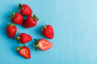 Mavi arka plan üzerinde olgunlaşmış taze çilek. Meyve yakın çekim