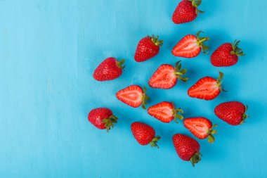 Mavi arka plan üzerinde olgunlaşmış taze çilek. Meyve yakın çekim
