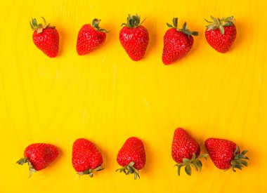 Sarı arka plan üzerinde olgunlaşmış taze çilek. Meyve yakın çekim