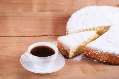 Ahşap masa üzerinde şekerli bisküvi kek. Ev pişirme. Kahve fincanı