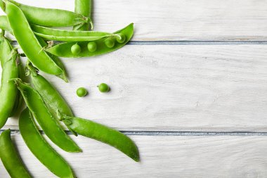 Taze yeşil bezelye ahşap masanın üzerine kapatın. Gıda katkı maddeleri. Üstten görünüm