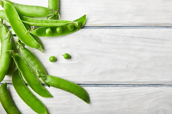 Taze yeşil bezelye ahşap masanın üzerine kapatın. Gıda katkı maddeleri. Üstten görünüm