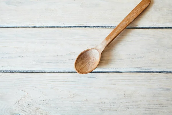 Wood spoon on white table. Cook. Food background