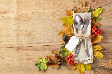 Şükran Günü güz yeri çatal bıçak takımı ve renkli sonbahar yapraklarıyla donatılmış.