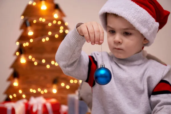 青いクリスマス ボールとサンタ帽子で Weared Unny 男の子 — ストック写真