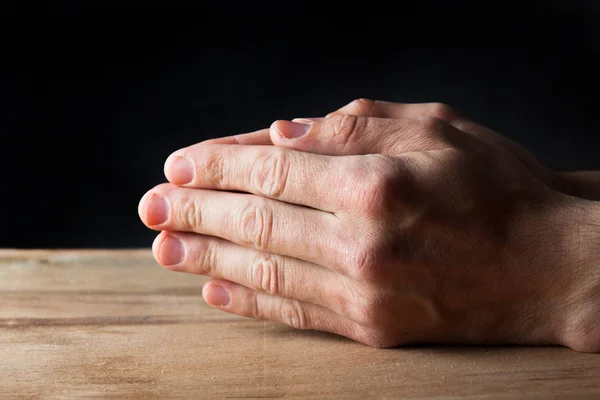 Mãos Homem Jovem Orando Fundo Mesa Madeira — Fotografia de Stock