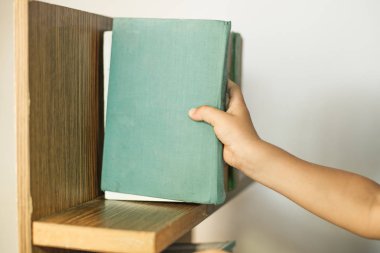 Erkek el seçimi ve halk kütüphanesiahşap kitaplık üzerinde beyaz kitap toplama.