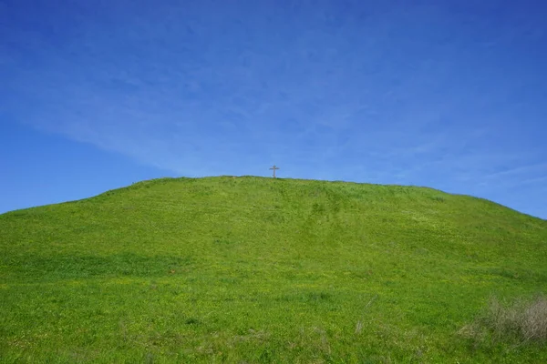 Cross on a green mountain against a blue sky. Pereslavl-Zalessky, Yaroslavl Oblast, Russia