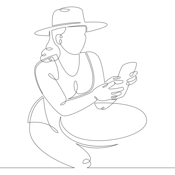 Mujer joven en un sombrero grande se sienta en una mesa con un teléfono inteligente — Archivo Imágenes Vectoriales