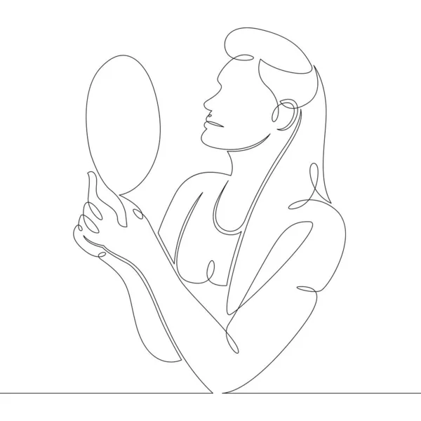 Young woman looks in a hand mirror — Stock Photo, Image