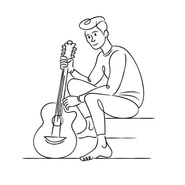 Νεαρός μουσικός κάθεται με μια κιθάρα. — Φωτογραφία Αρχείου
