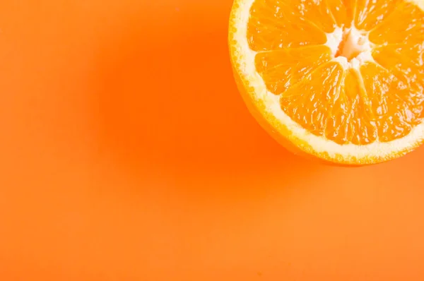 Turuncu renkli arka plan üzerinde yarım turuncu meyve üstten görünüm