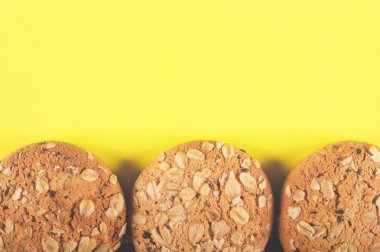 Yulaf ezmeli kurabiye ile yulaf gevreği ve tohum sarı bir arka plan üzerine bir tutam