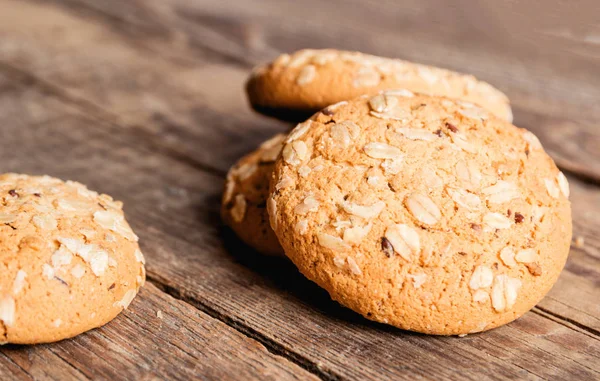 Yulaf ezmeli kurabiye ile yulaf gevreği ve tohum bir ahşap zemin üzerine bir tutam