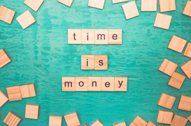 Mavi bir arka plan üzerinde alfabe kavramının ahşap harfleri ile ortaya konulan para kelime zamanı