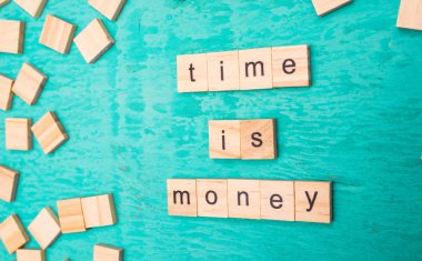 Mavi bir arka plan üzerinde alfabe kavramının ahşap harfleri ile ortaya konulan para kelime zamanı