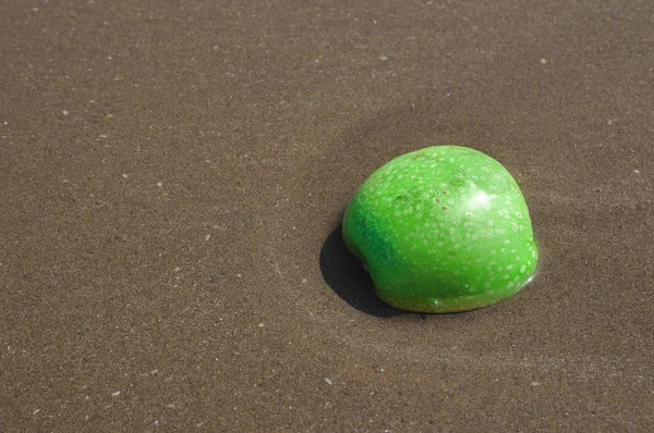 浜辺の砂の緑のリンゴ — ストック写真