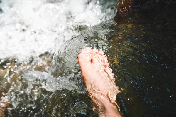 Чоловіки ноги в потоці води серед річки — стокове фото