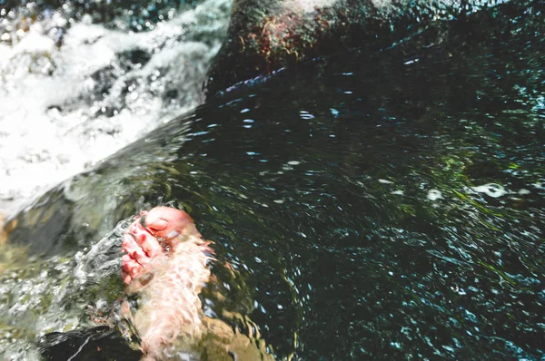 Männer Füße in einem Wasserstrom zwischen dem Fluss — Stockfoto