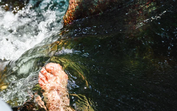 Männer Füße in einem Wasserstrom zwischen dem Fluss — Stockfoto