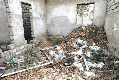Çöp yığını ile bitmemiş terk edilmiş ev