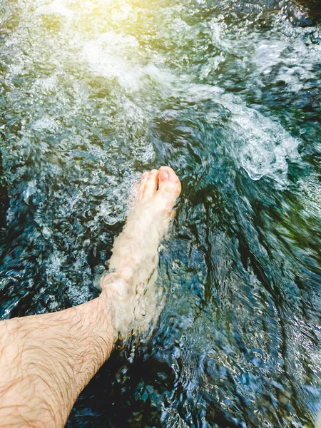 Männer Füße in einem Wasserstrom zwischen dem Fluss — Stockfoto