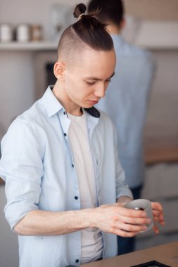 Genç bir adam olarak bir Barista samimi bir kafede çalışıyor. O kahve makinesi standları ve kahve biler.