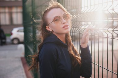 Güzel bir kız bir yaz akşamı güneş gözlüğü standları ve Bahçesi gülümsüyor