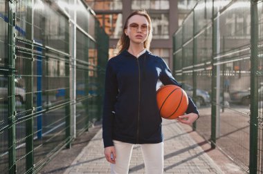 Spor kız kendinden emin bir güneşli akşam daimi bir basketbol el ile basketbol sahası