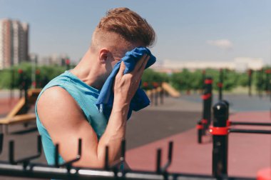 Bir egzersiz havlu ter onun yüzünü mendil sonra genç bir adam