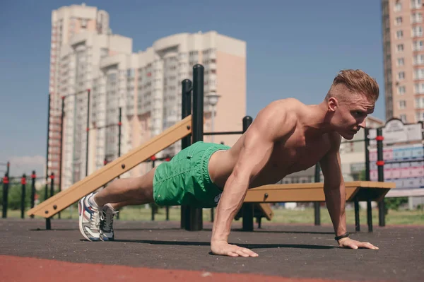 Sportler Auf Dem Straßenspielplatz Beim Sport Und Liegestützen Vom Boden lizenzfreie Stockbilder