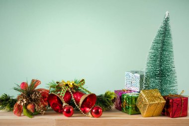 Noel arka plan. Küçük bir Noel ağaç ve ahşap bir masa üzerinde hediye kutuları. Yeşil arka plan. Metin için yer. Yeni yıl arka plan.