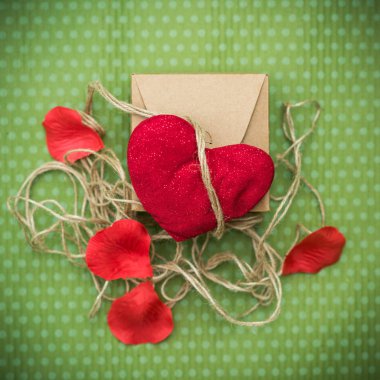 Sevgililer günü. Kırmızı bir kalp ile bağlı bir hediye kutusu için eski bir iş parçacığı bir yeşil polka dot arka plan üzerinde yatıyor. Sevgililer günü. Kalp Kolye. Metin için yer. Kırmızı kalp. 8 Mart. Dünya Kadınlar günü.