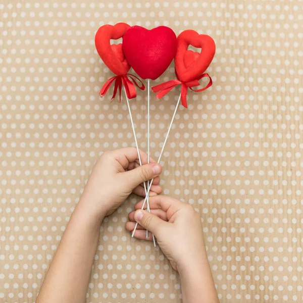情人节 那孩子在用白豆写的纸板纸的背景下 把红心抱在棍子上 情人节 心脏吊坠 文本的空间 3月8日 — 图库照片