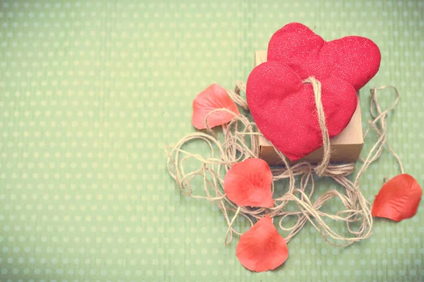 Red heart wrapped in vintage thread on green background — Stock Photo, Image