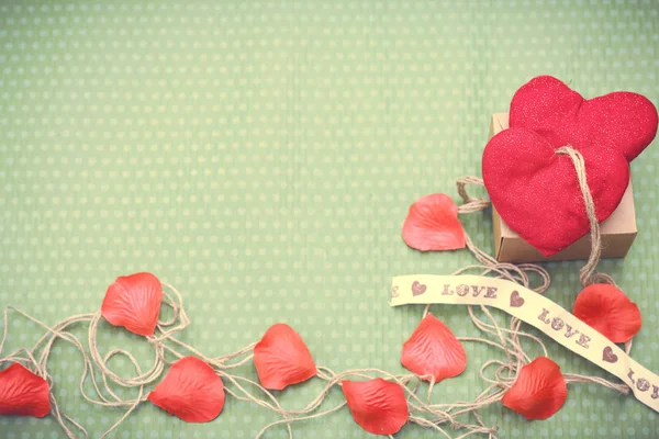 Red heart wrapped in vintage thread on green background — Stock Photo, Image