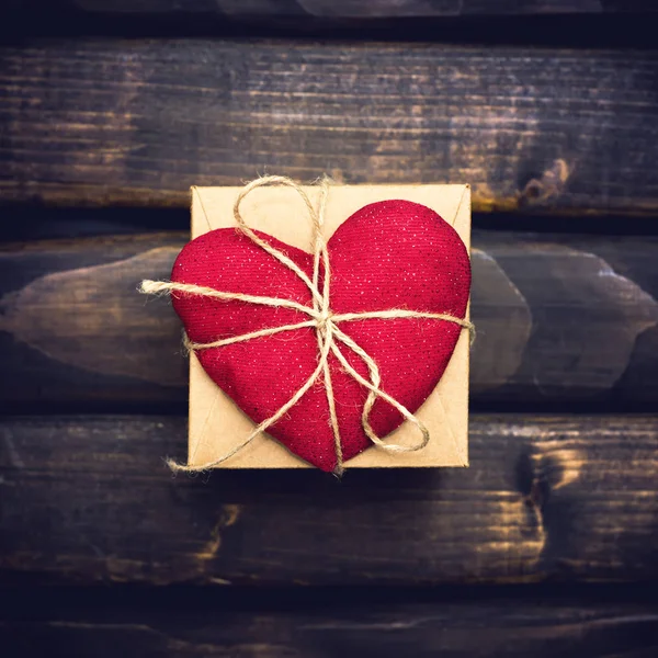 Coeur rouge sur la boîte cadeau sur les planches — Photo